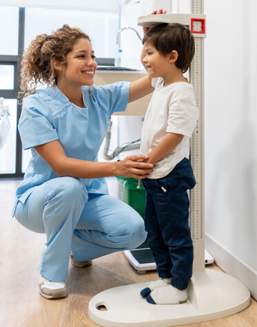 nurse measuring little boy's height